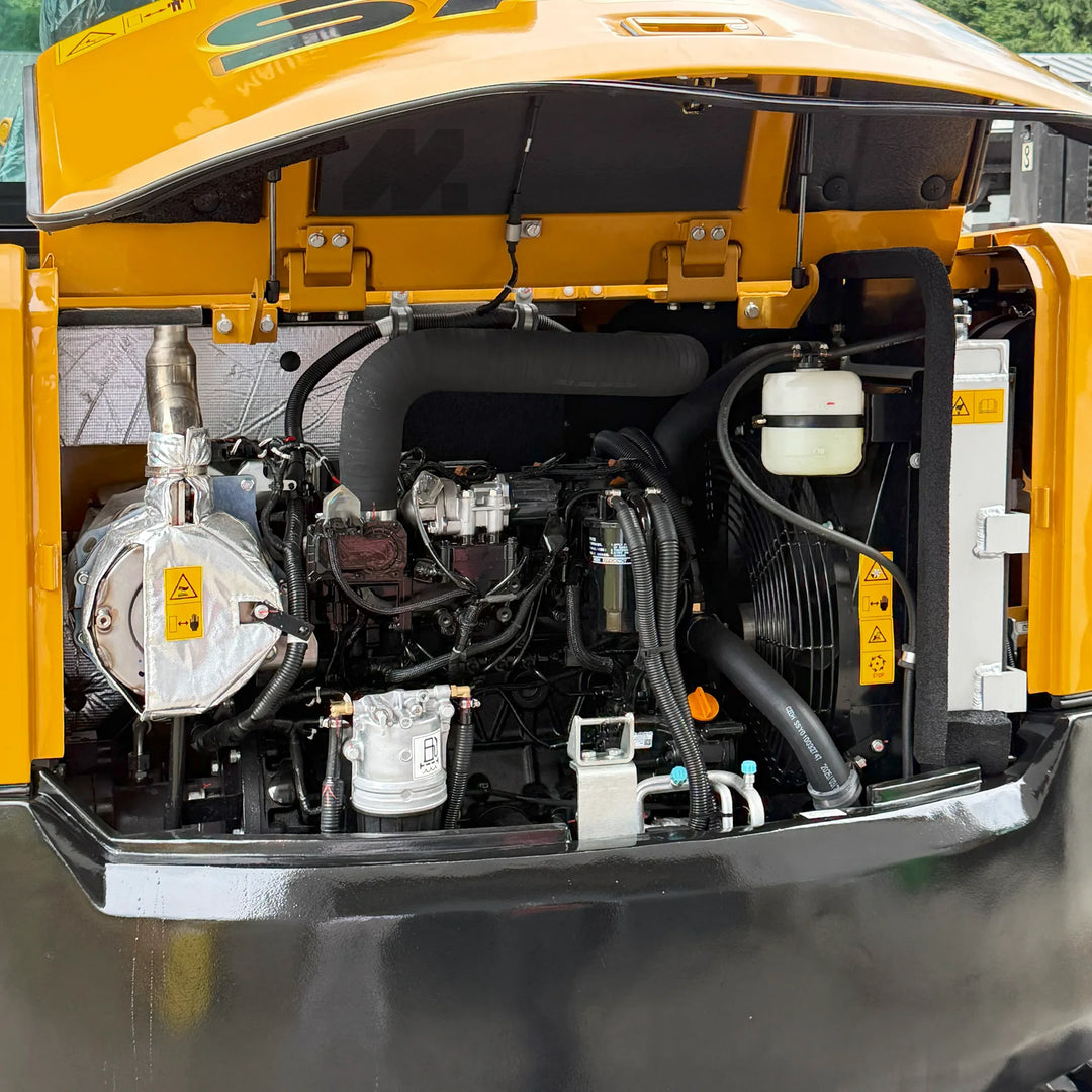 Silnik Yanmar w koparce SANY SY60U, widok komory serwisowej z przewodami, chłodnicą i elementami układu hydraulicznego przy otwartej klapie.