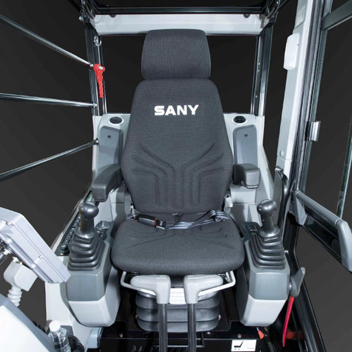 Ergonomiczne wnętrze kabiny kparki SANY SY155U PB - widok na amortyzowany fotel operatora z logo SANY, dżojstiki sterujące oraz intuicyjny wyświetlacz pokładowy.