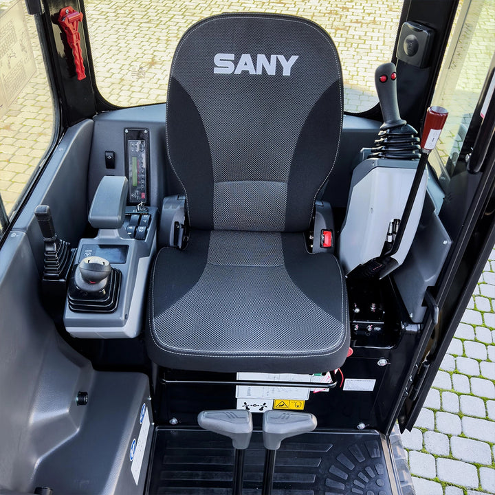 Wnętrze kabiny minikoparki Sany SY18C z ergonomicznym fotelem operatora, logo Sany i panelami sterowania