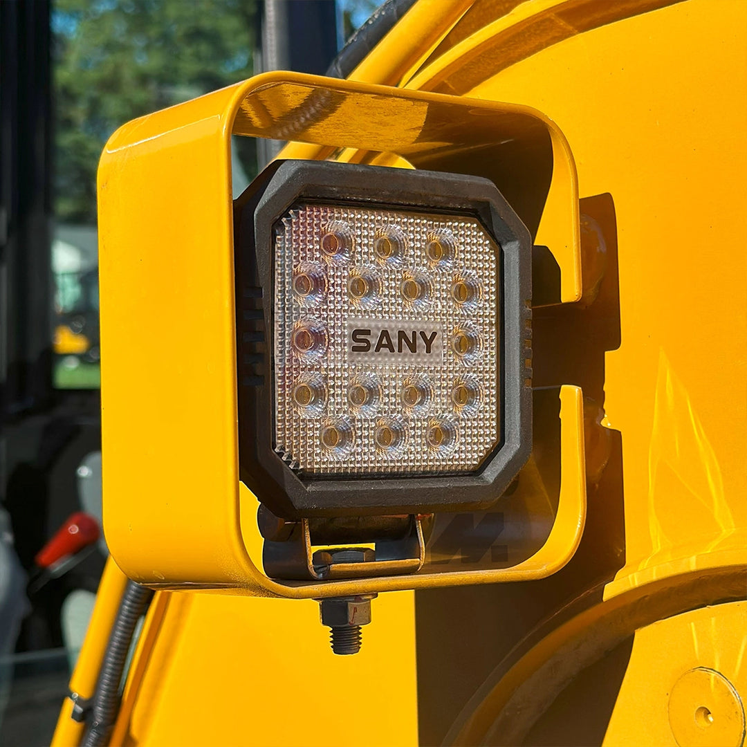 Reflektor roboczy LED z logo Sany w osłonie ochronnej zamontowany na wysięgniku minikoparki Sany SY18C