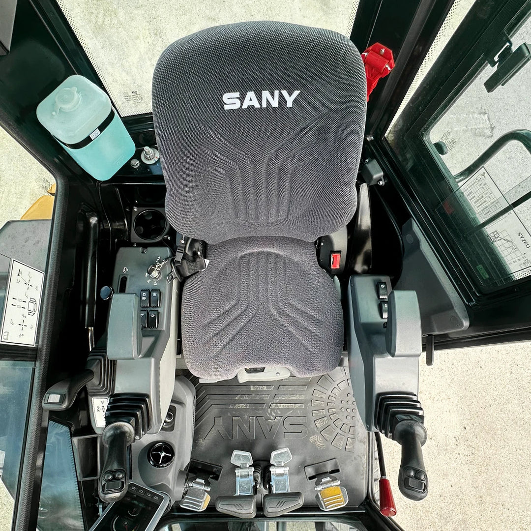 Wnętrze kabiny SANY SY26U - widok z góry na ergonomiczne stanowisko operatora, joysticki sterownicze i gumową wycieraczkę z logo SANY.