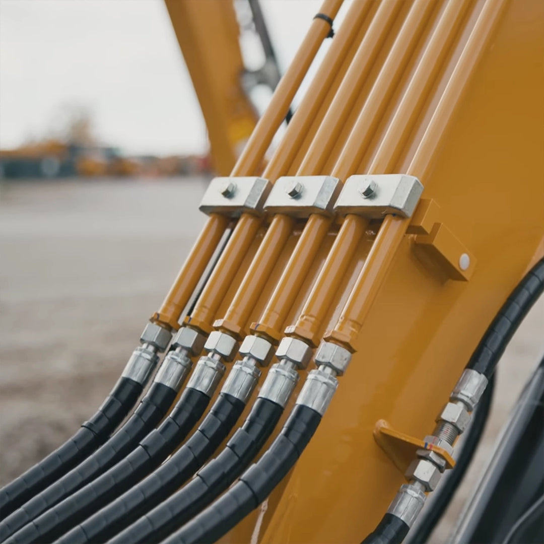 Zbliżenie na wysokociśnieniowe węże hydrauliczne na ramieniu modelu Sany SY35C