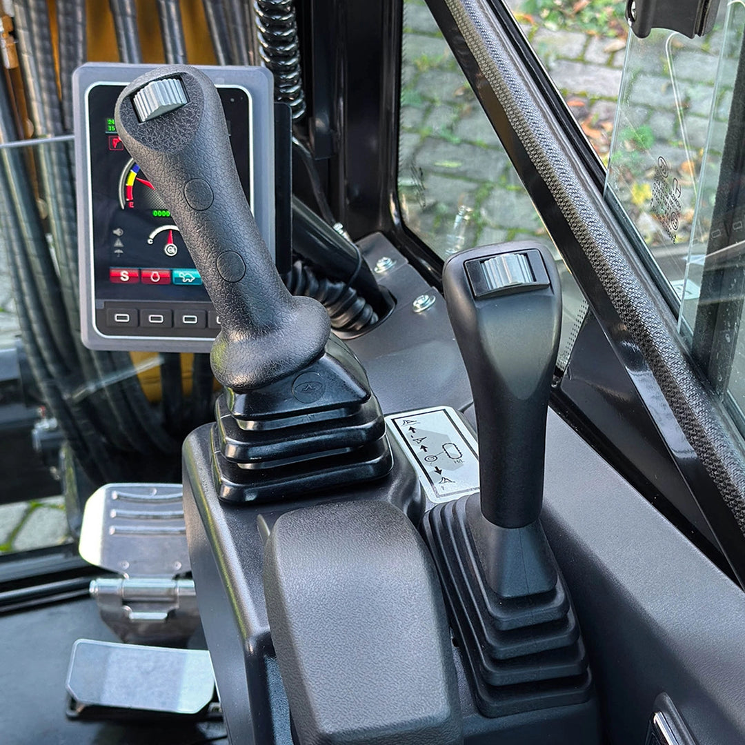 Ergonomiczne stanowisko operatora w minikoparce Sany SY35U - zbliżenie na precyzyjne joysticki sterujące i wykończenie wnętrza kabiny.