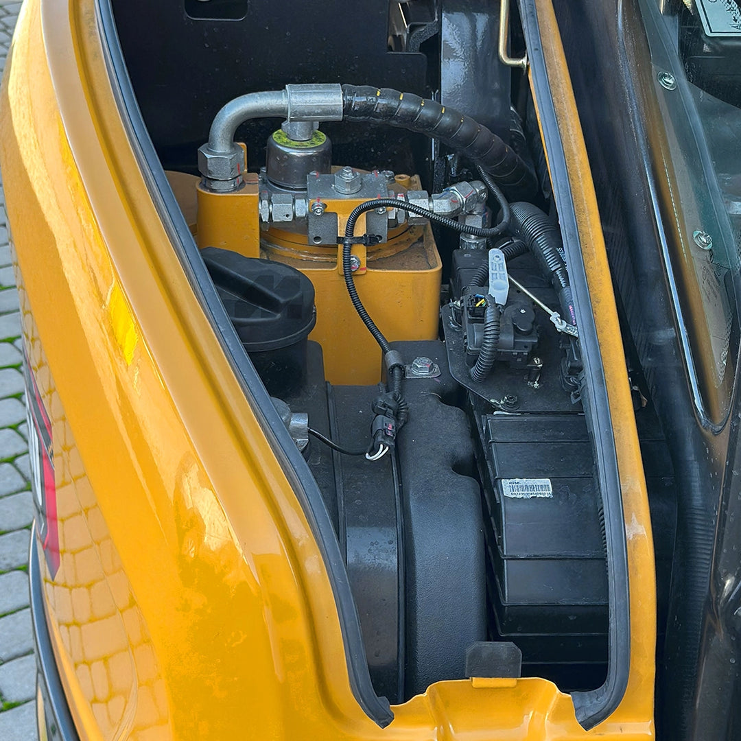 Dostęp serwisowy w minikoparce SANY SY35U - przejrzyste rozmieszczenie podzespołów, akumulatora i filtrów pod maską maszyny.