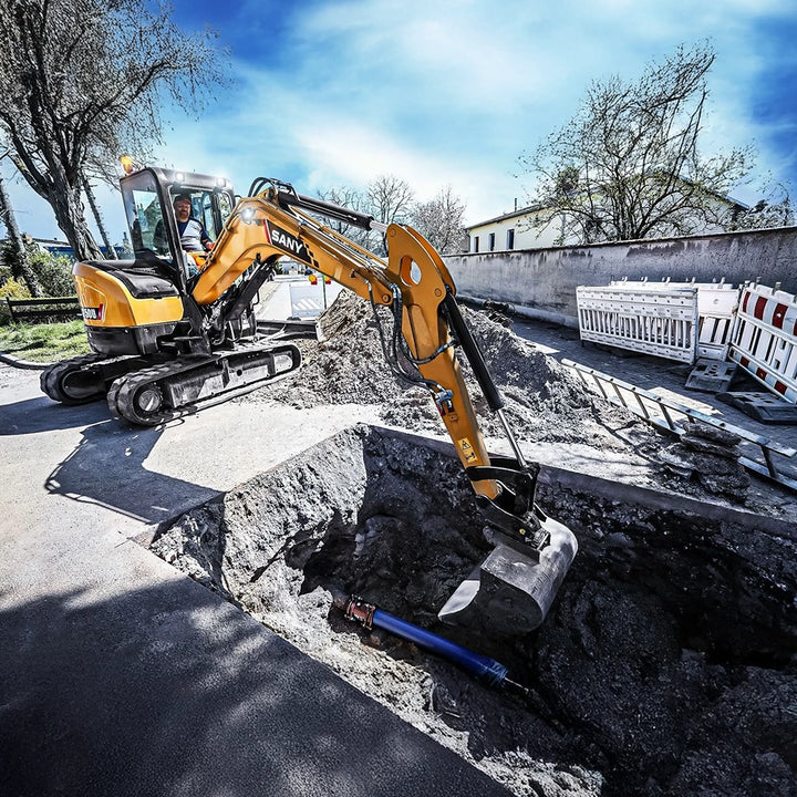 Minikoparka 5 ton SY50U podczas kopania głębokiego rowu pod przyłącz w asfalcie na placu budowy.