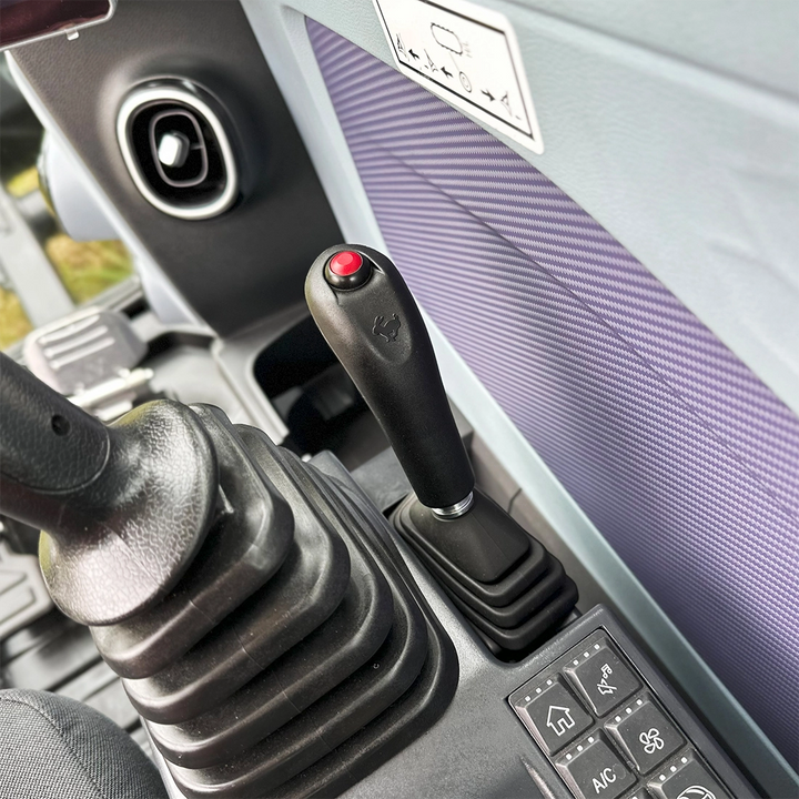 Joystick sterujący z funkcją płynnego lemiesza oraz panel przycisków w kabinie minikoparki Sany SY60U.