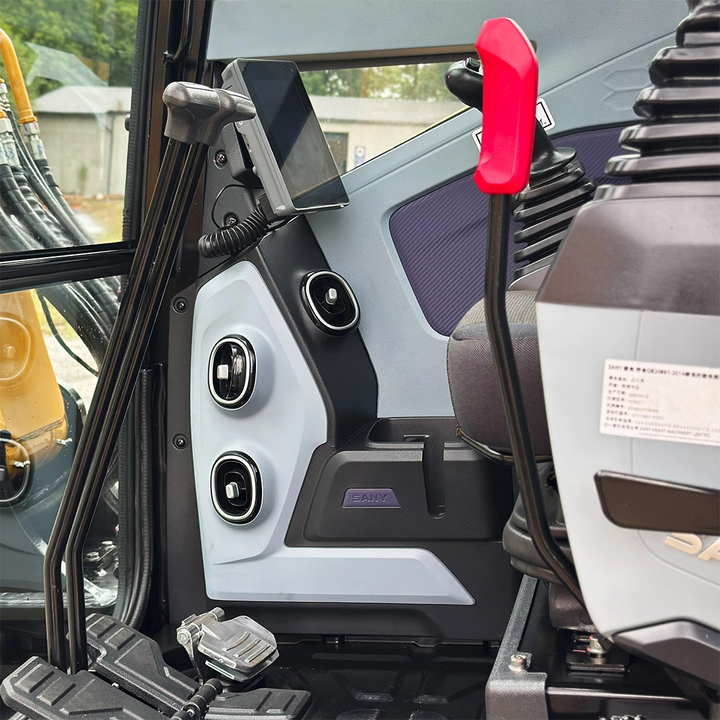 Wnętrze kabiny Sany SY60U: panel z regulowanymi dyszami nawiewu, kolorowy wyświetlacz LCD oraz ergonomiczne dźwignie sterujące.